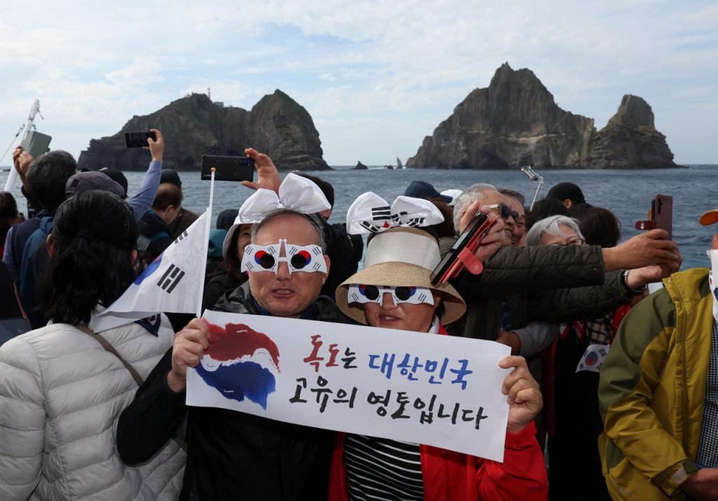 Un couple coréen qui brandit "Dokdo est le territoire de la Corée du Sud" au large des îlots le 19 octobre 2023 (The Korea Herald).