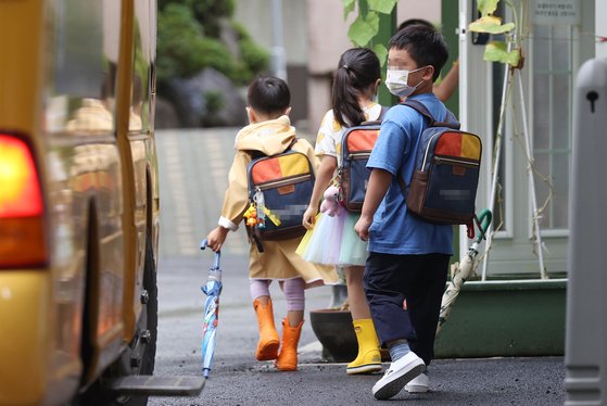 Des enfants qui se préparent à prendre le bus scolaire (Yonhap).