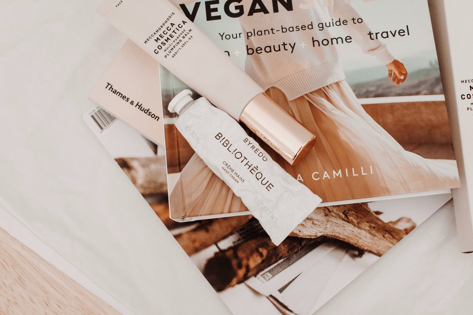 Tubes de produits de beauté blancs posés sur des magazines 